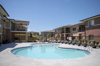 Resort style swimming pool with sun tanning loungers at The Villas of Omaha at Butler Ridge in Omaha, Nebraska