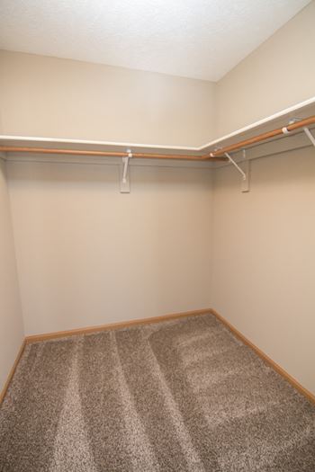 Large walk in closet with shelving and hanging space Swimming pool with sun tanning loungers at Williamsburg Park Apartments in South Lincoln, Nebraska