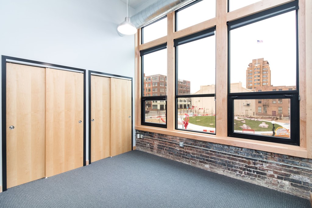 a room with large windows and a brick wall