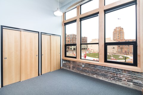 a room with large windows and a brick wall