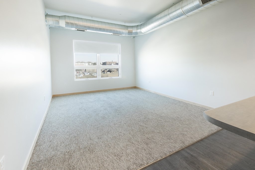 an empty room with white walls and a window