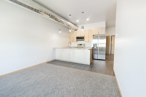 a kitchen with a white counter top and a stainless steel refrigerator