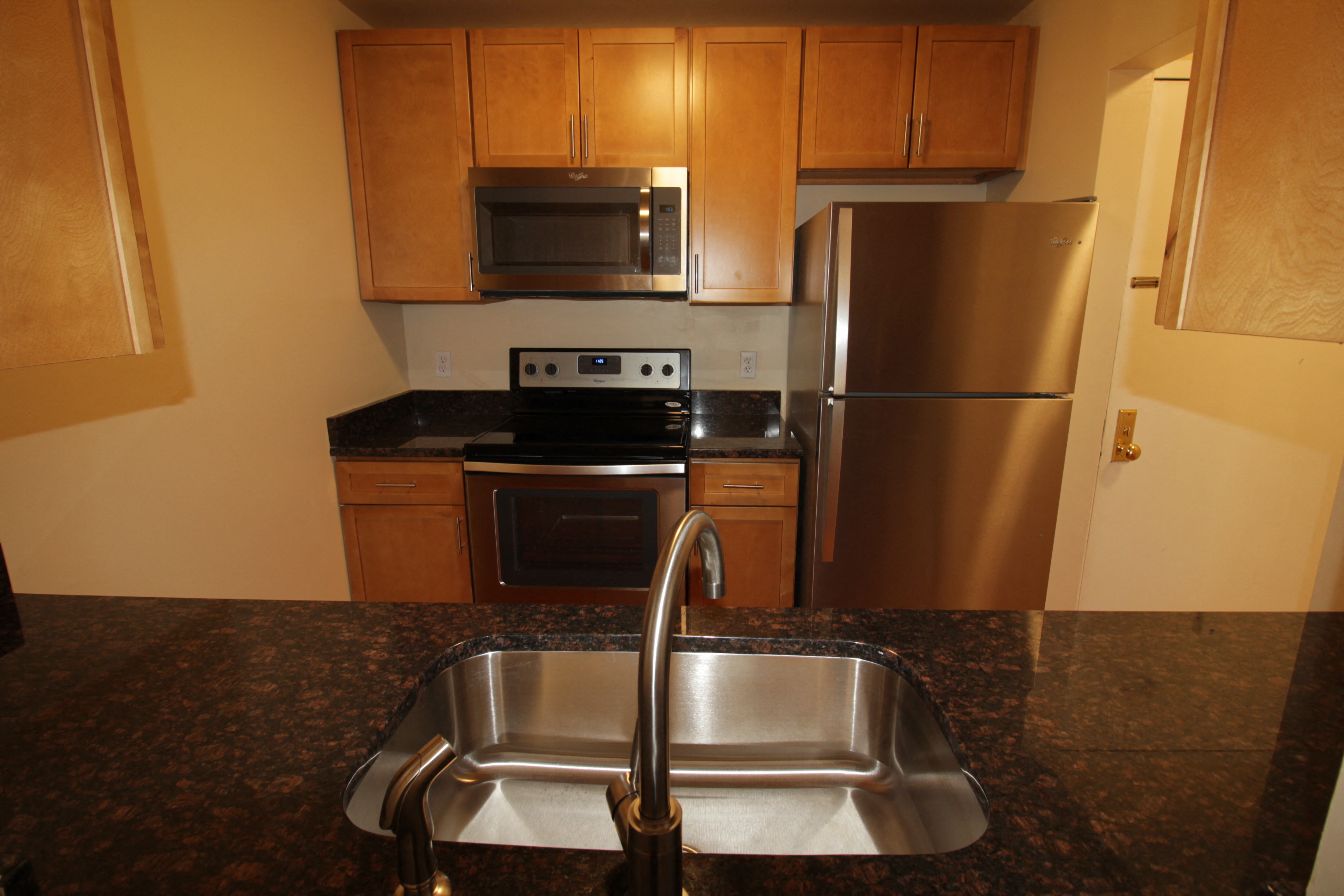 A kitchen with a sink and a refrigerator.