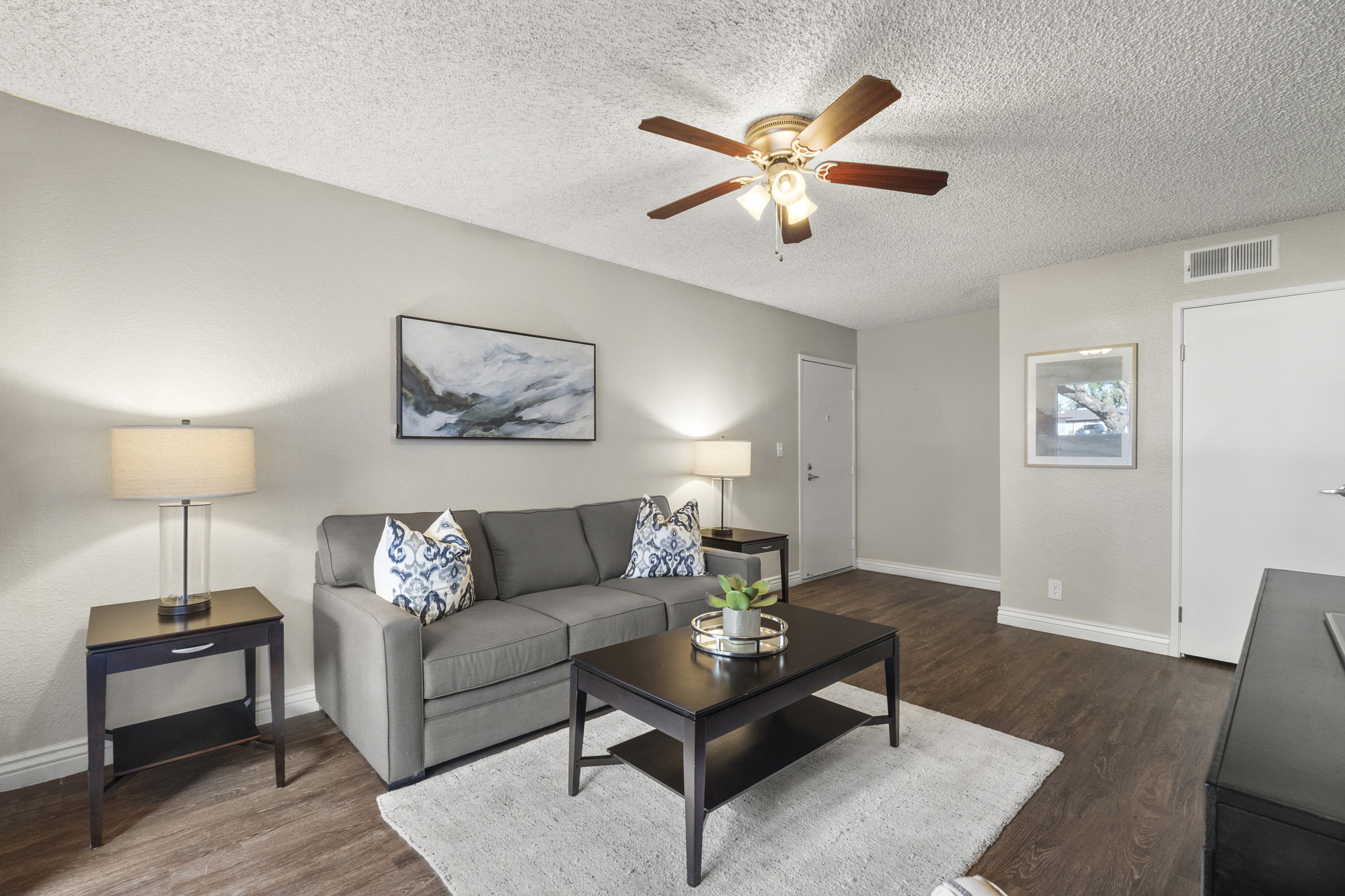 a living room with a couch and a ceiling fan