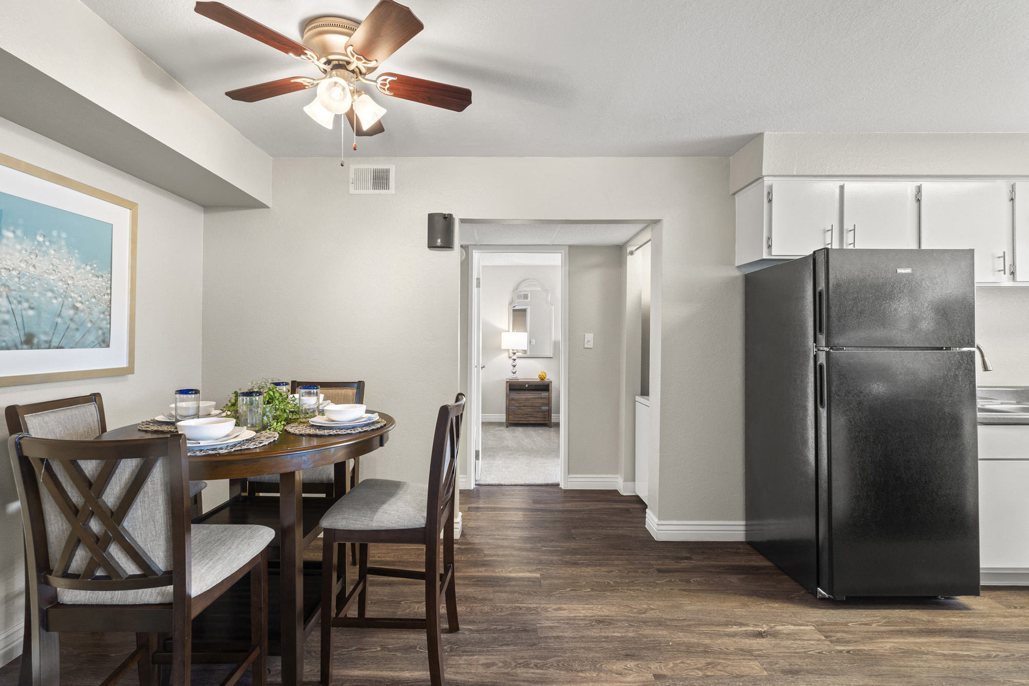 a kitchen and dining room with a refrigerator and a ceiling fan