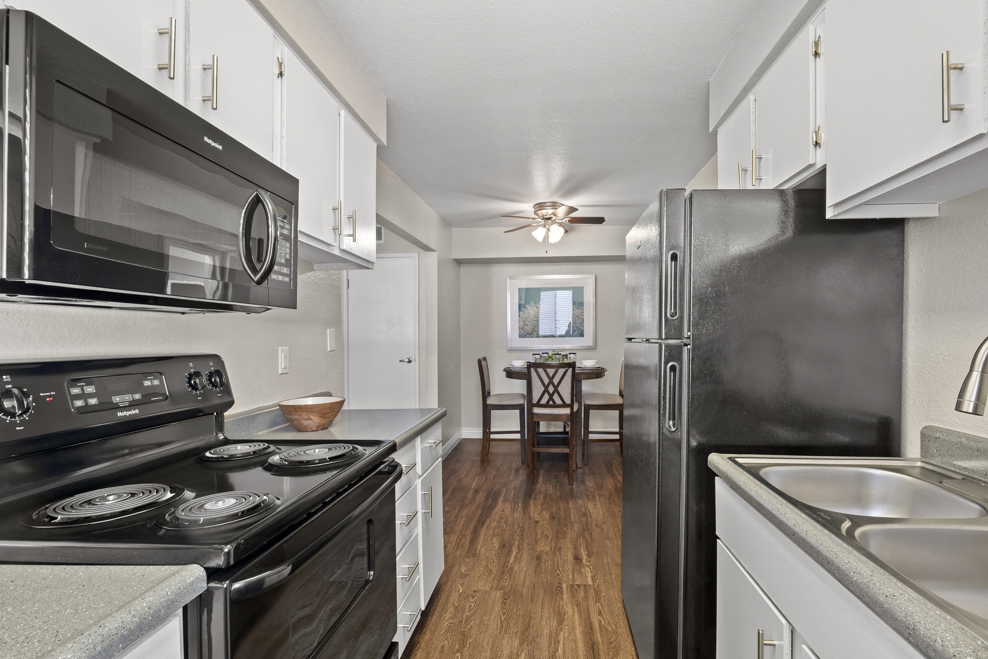 an updated kitchen with black appliances and white cabinets