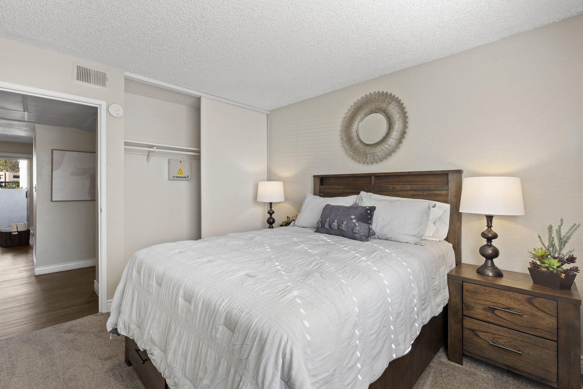 a bedroom with a white bed and a dresser