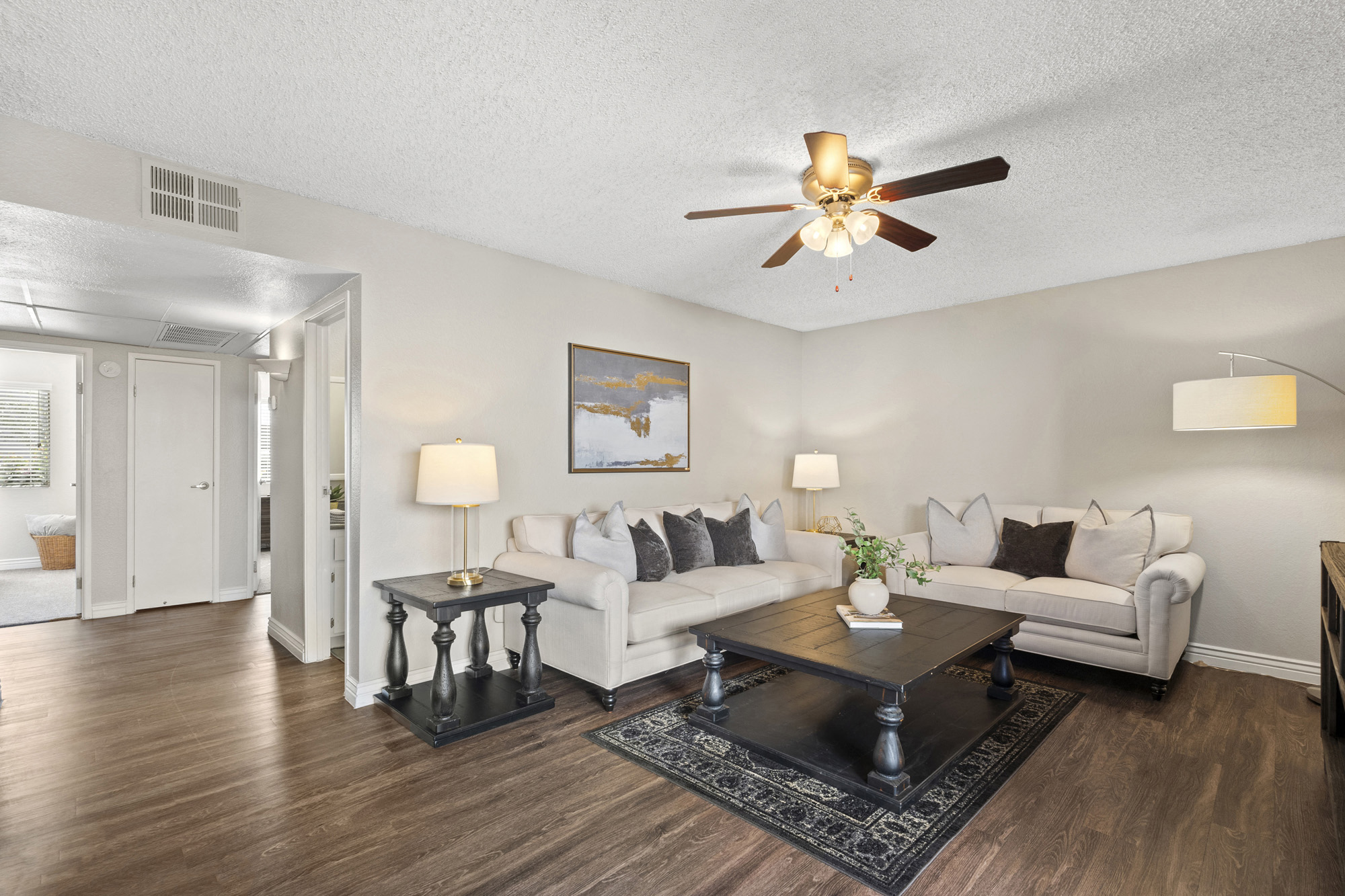 a living room with a ceiling fan and couches