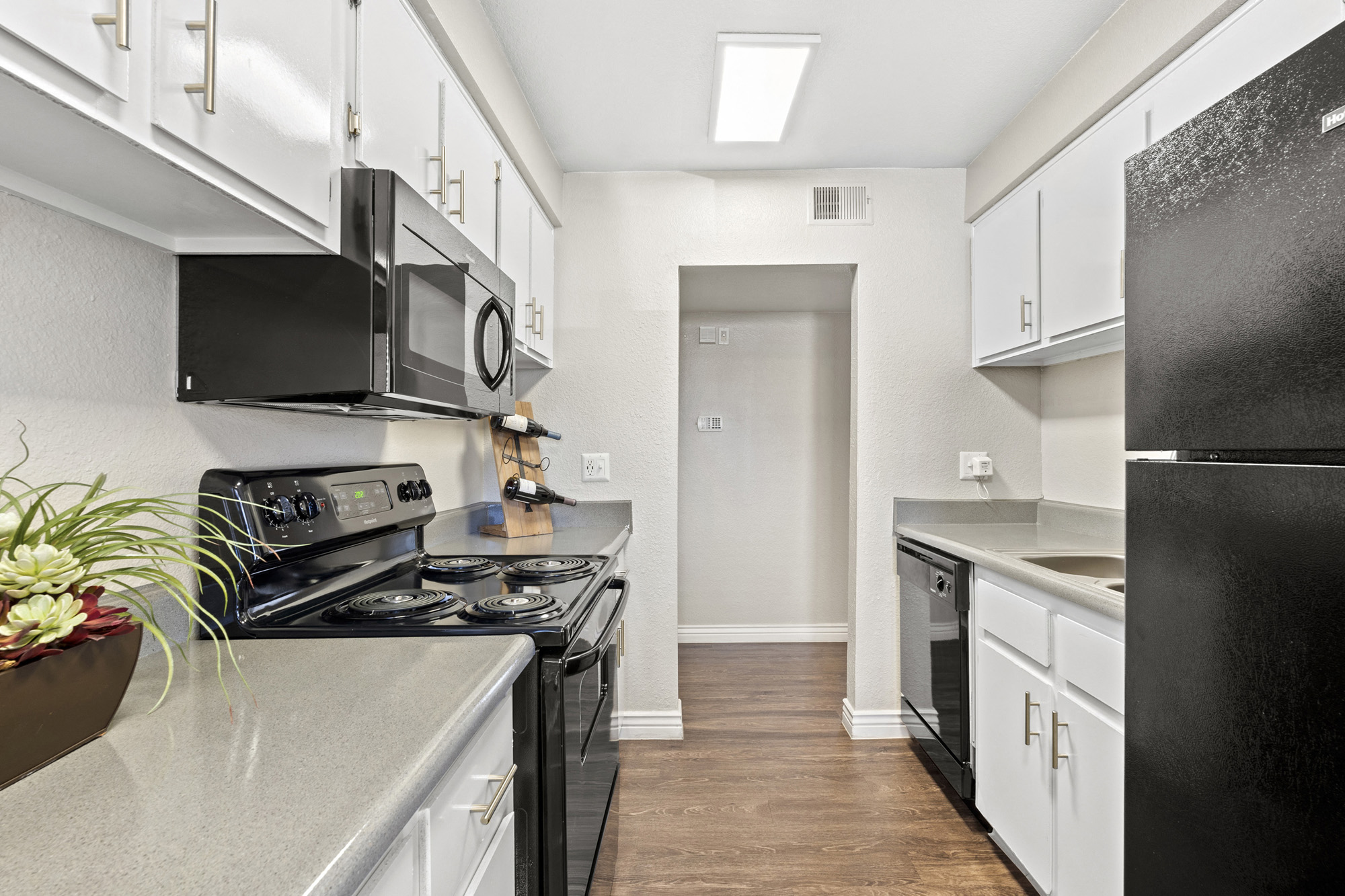 a renovated kitchen with black appliances and white cabinets