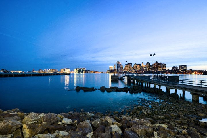 a pier on the water with a city in the background