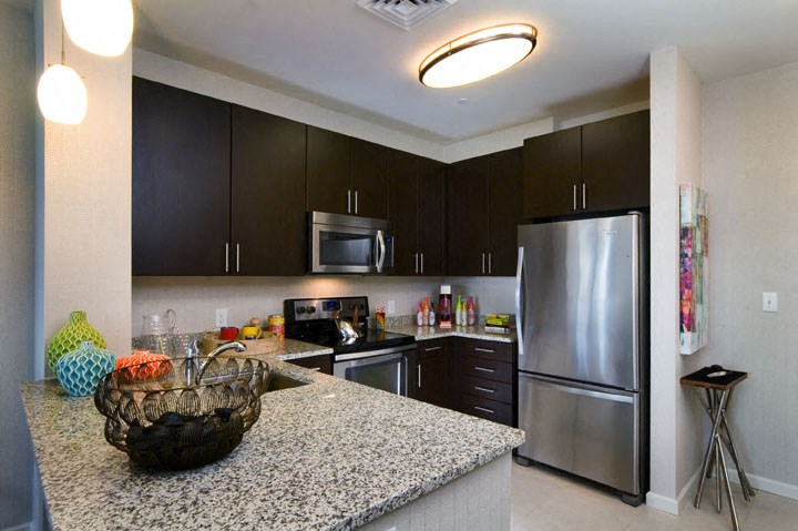 a kitchen with a granite counter top and a stainless steel refrigerator