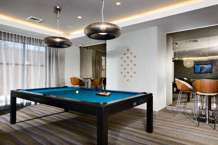 a billiards table in a room with a bar and chairs