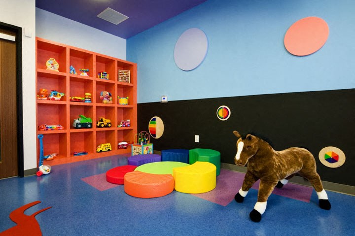 a stuffed horse in a play room with toys