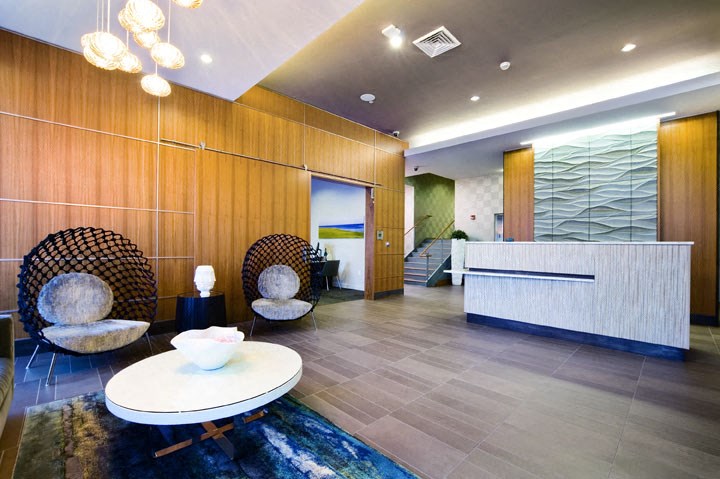 a lobby with chairs and a table and a reception desk
