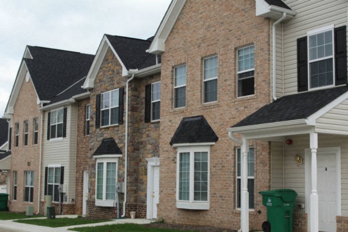 a row of houses with brick and white siding