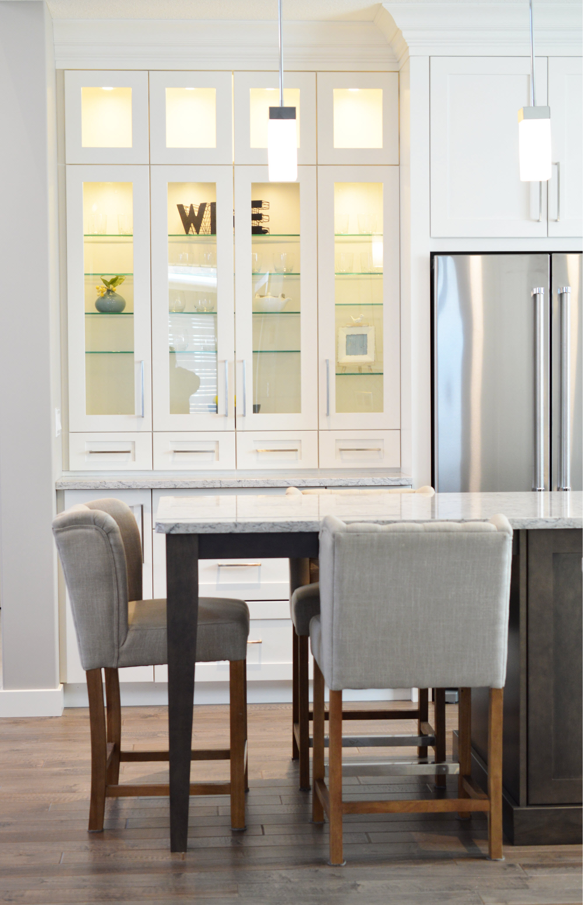 a kitchen with white cabinets and a table with chairs