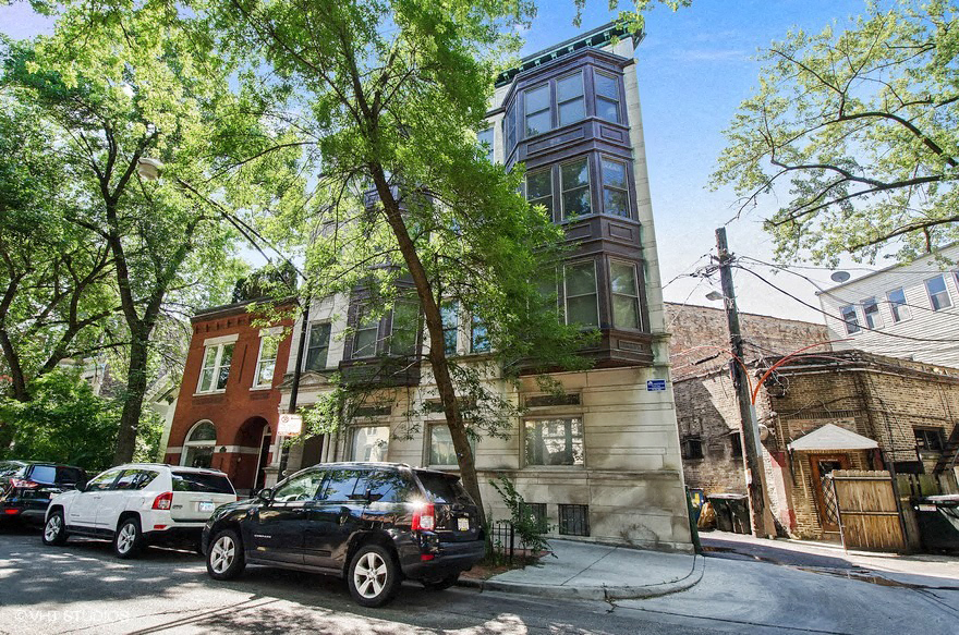a black car parked in front of a tall building