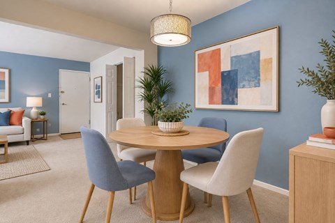A dining room with a round table and chairs.