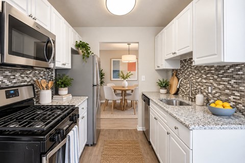 A kitchen with white cabinets and a black stove top oven.