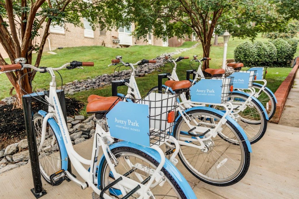 a row of blue and white bikes parked on a sidewalk
