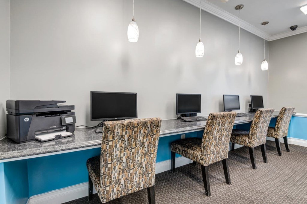 a business center with computers and chairs and a printer