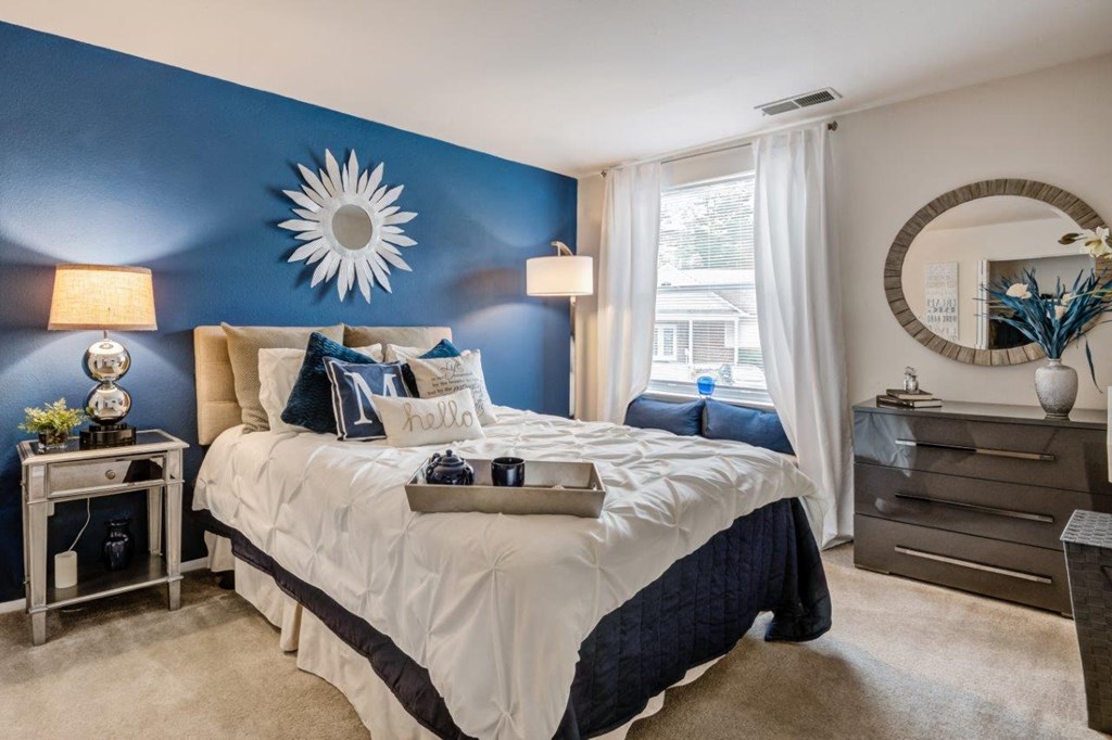 a bedroom with a blue accent wall and a bed