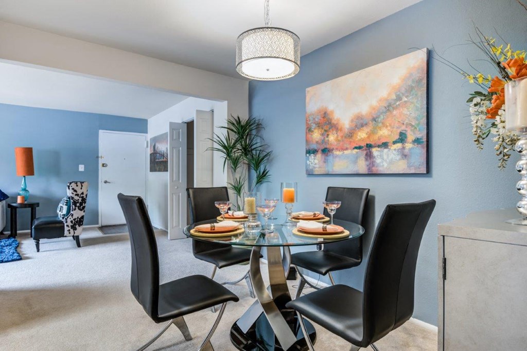 a dining room with a glass table and chairs