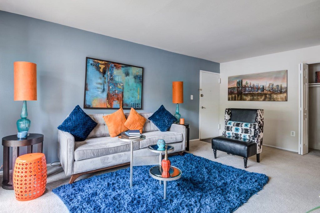 a living room with a couch and a chair and a rug