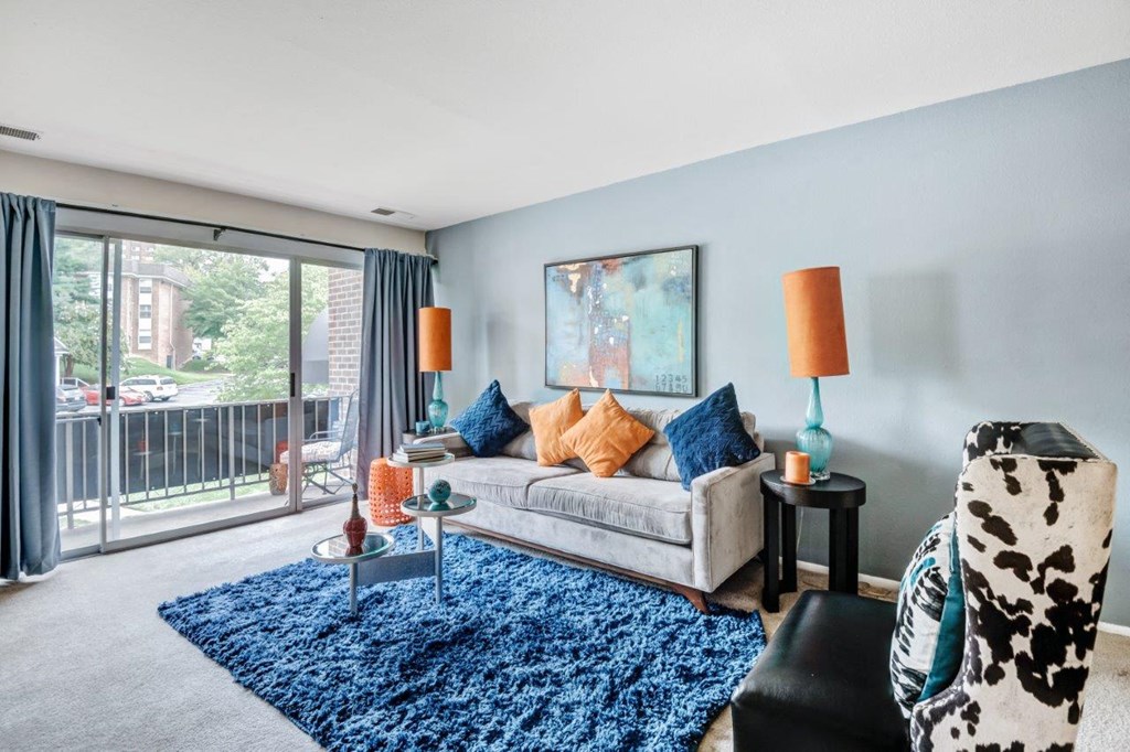 a living room with a couch and a chair and a sliding glass door