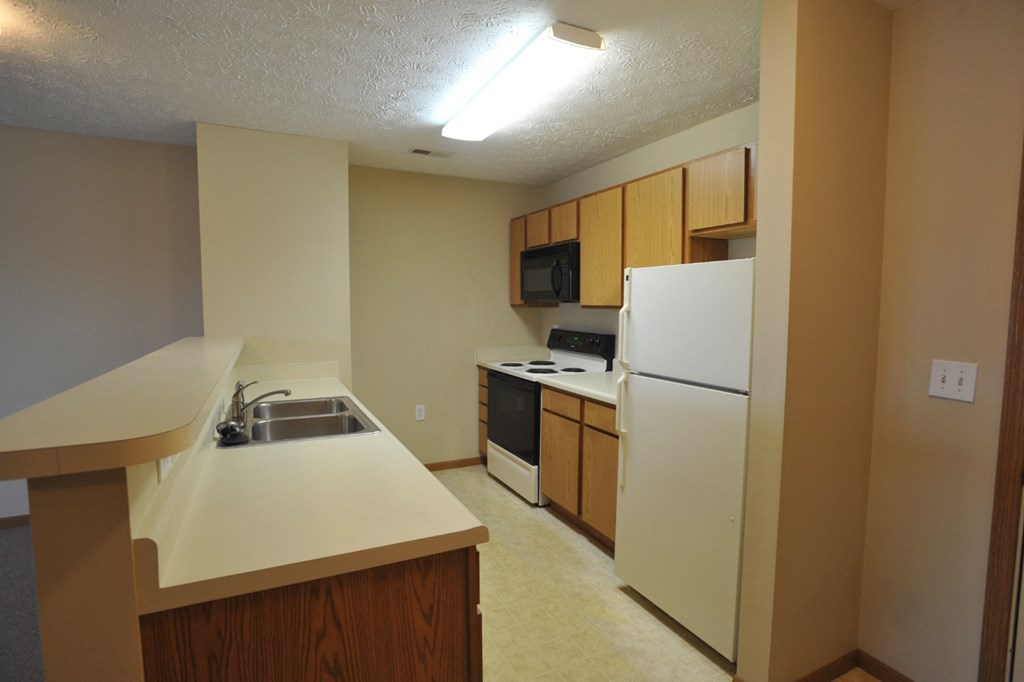 a kitchen with white appliances and a sink and a refrigerator