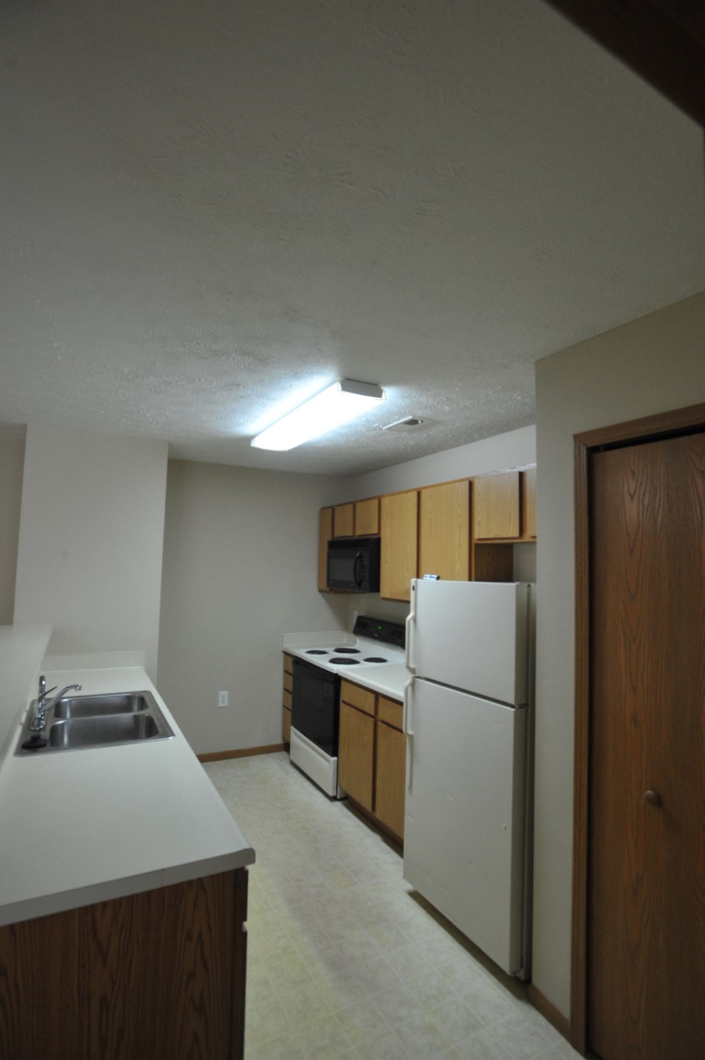 a kitchen with white appliances and a refrigerator and a sink