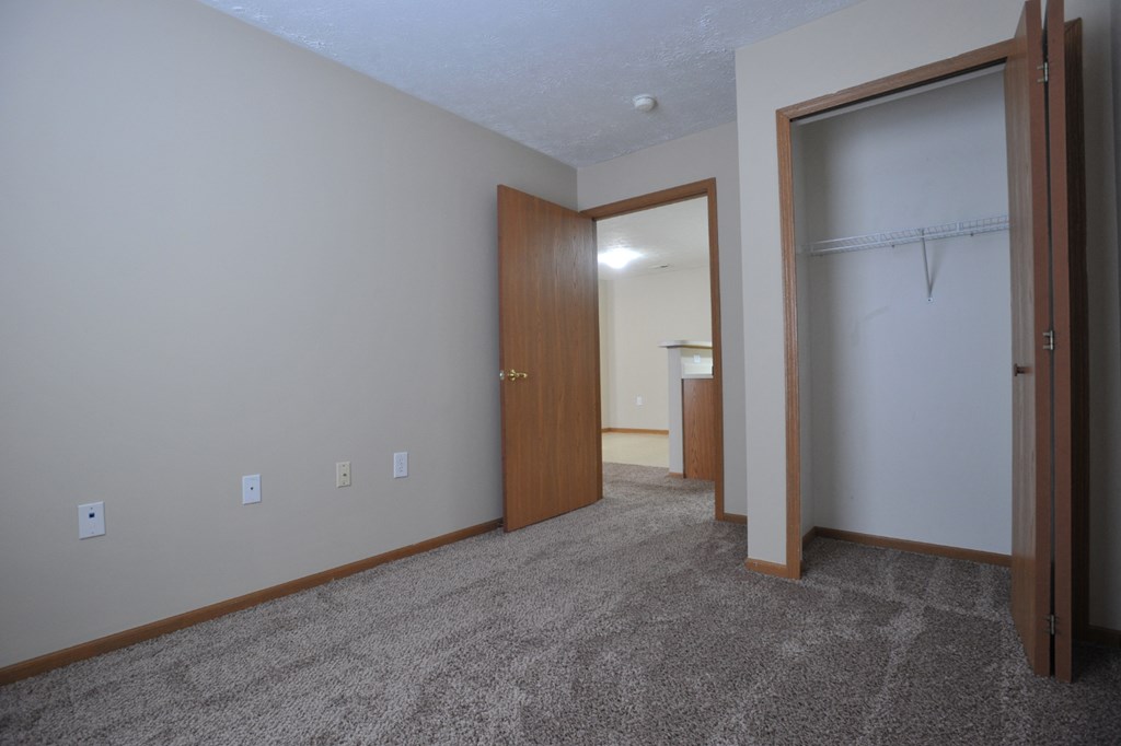 a room with a carpeted floor and a door to a bathroom