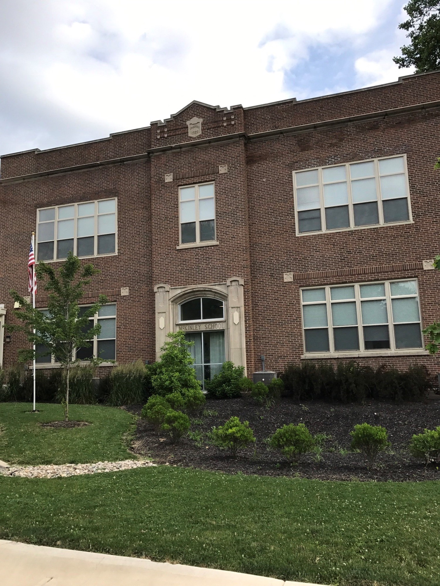 the front of a brick building with a lawn