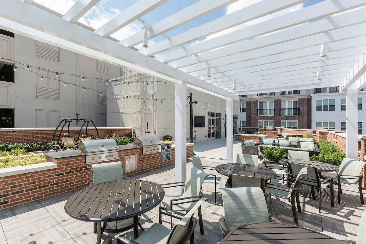 a patio with tables and chairs and a white canopy