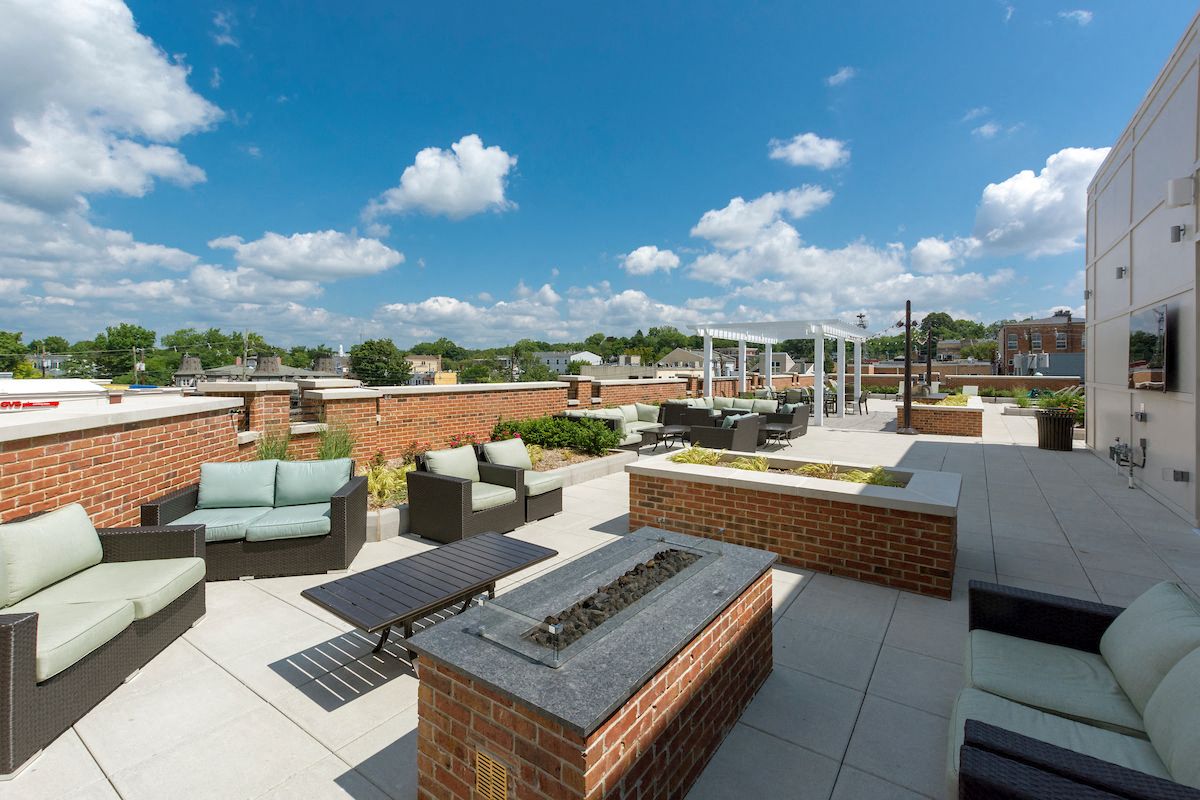 a rooftop patio with furniture and a fire pit
