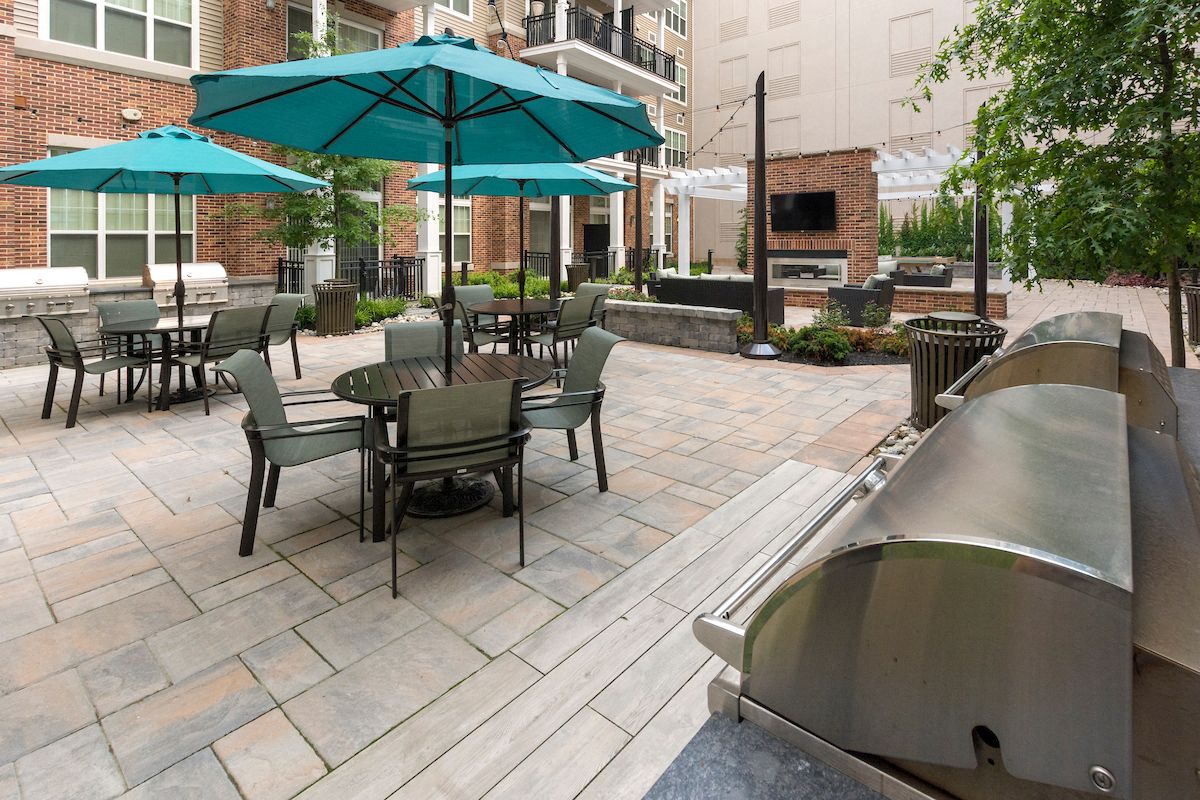 a patio with tables and umbrellas and a fire pit