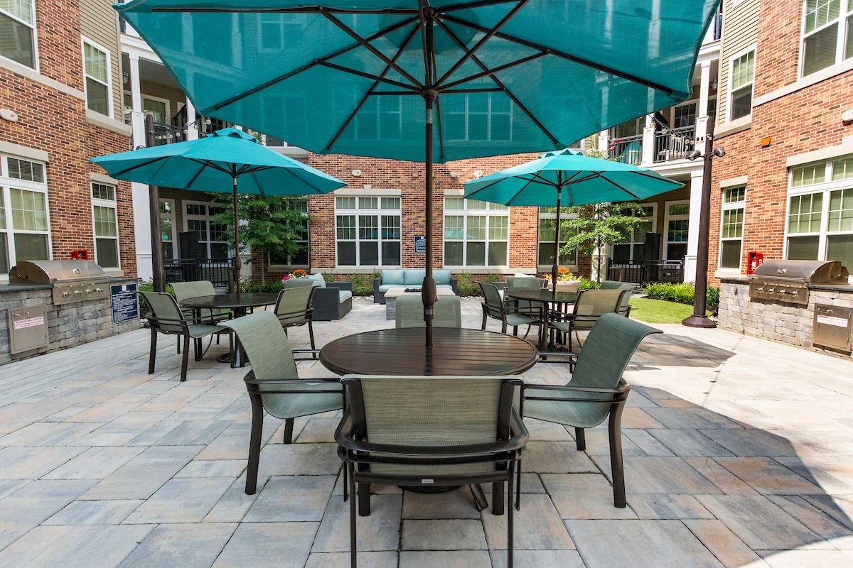 a patio with chairs and tables with umbrellas