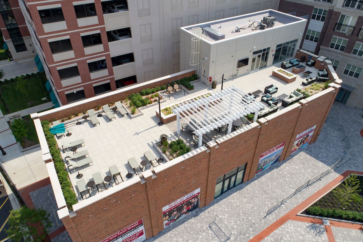 an aerial view of the rooftop of a building with tables and chairs on it