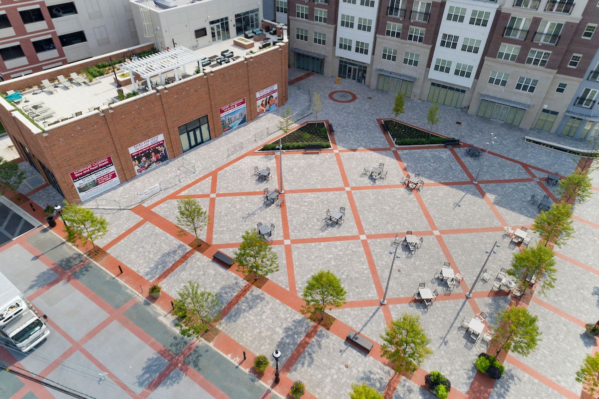 an aerial view of a city square with trees and buildings