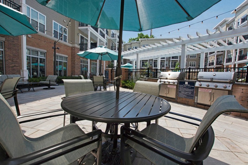 a patio with umbrellas and a table with chairs