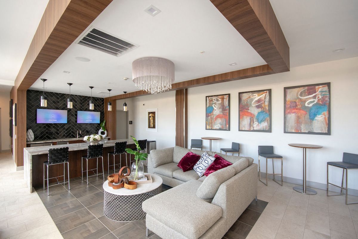 the lobby of a hotel with a living room and a bar