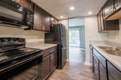 the kitchen of a home with black appliances and wooden cabinets