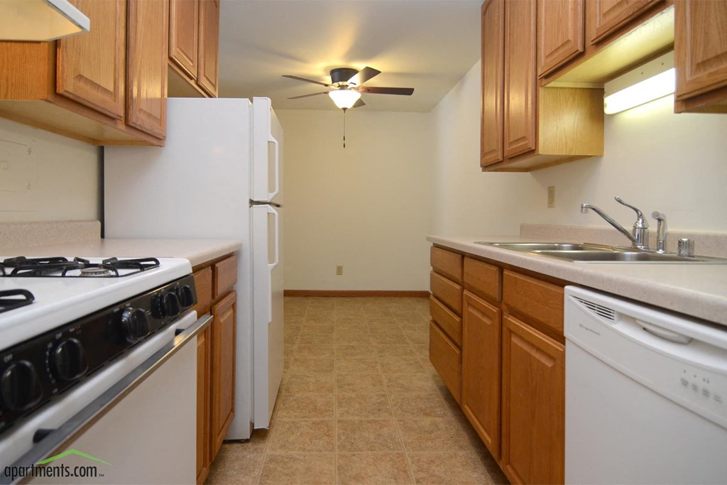 a kitchen with white appliances and wooden cabinets