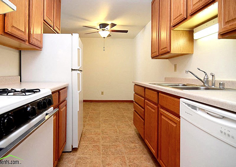 a kitchen with white appliances and wooden cabinets