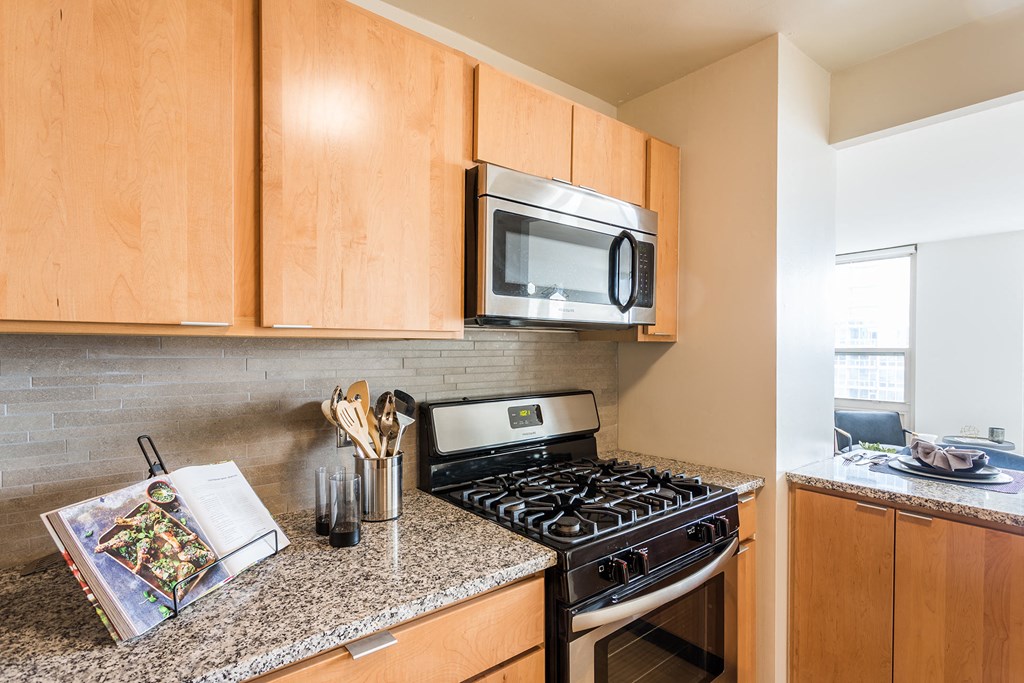 a kitchen with a stove and microwave and wooden cabinets