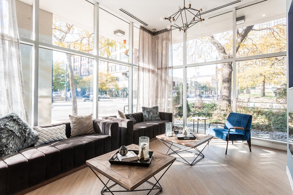 a living room with couches and tables and large windows