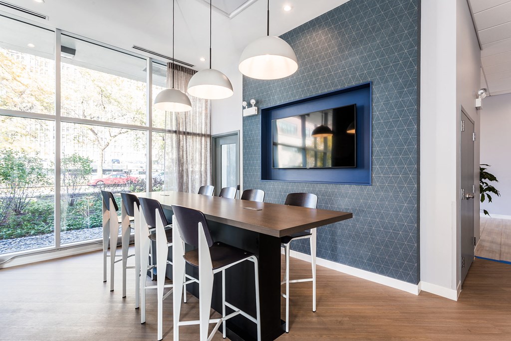 a dining room with a table and chairs and a tv on the wall