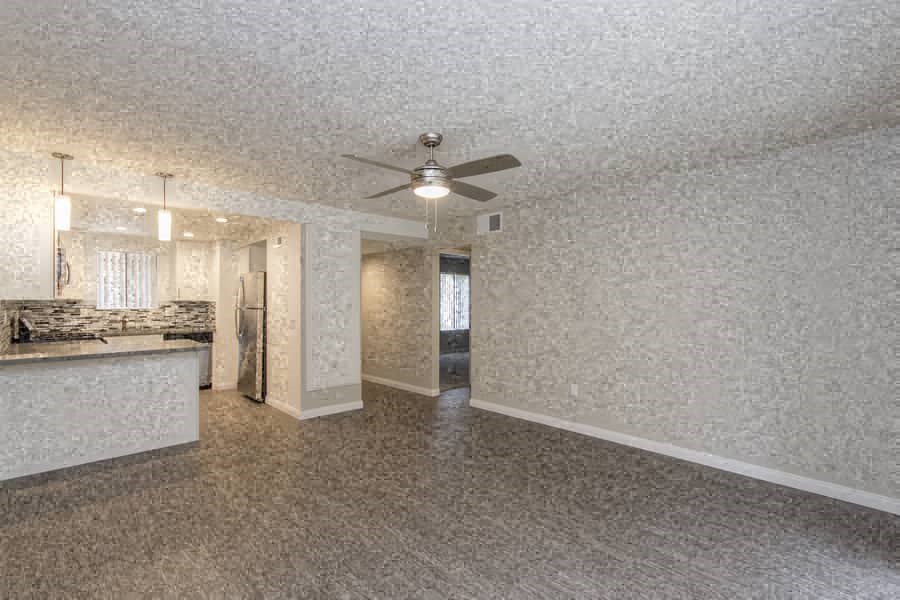an empty kitchen and living room with a ceiling fan