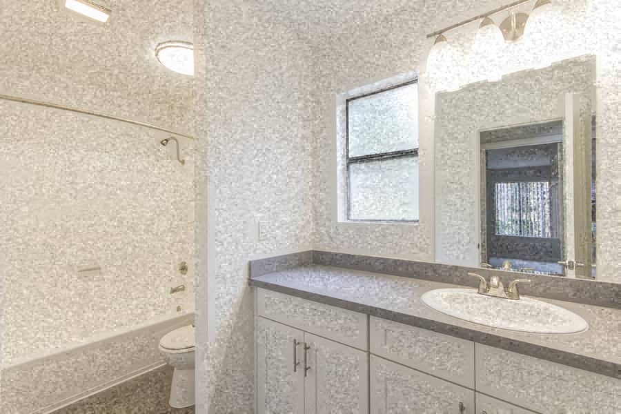 a white bathroom with a sink and a mirror