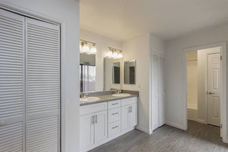 a white bathroom with two sinks and a mirror